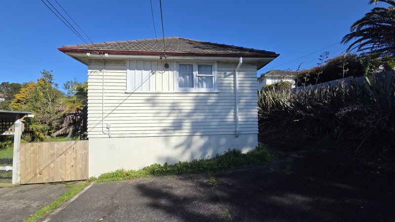 Exterior of the two bedroom home with timber weatherboards and a concrete tile roof