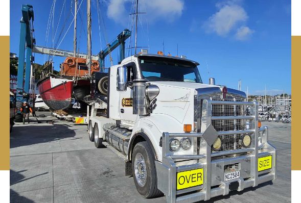 An oversized structure secured on a low loader with oversize load signage fitted